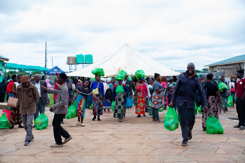 Community members carrying Christmas hampers home after the distribution